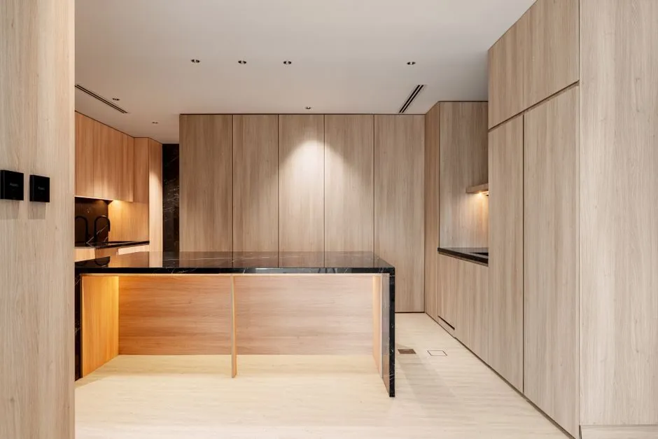sleek kitchen island with marble waterfall edge and bar stools